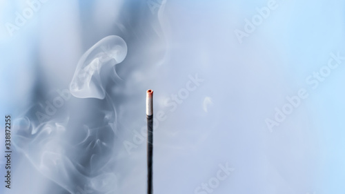 incense smoke. smoldering piece of wood . incense sticks in blue lighting. aromatic smoke .