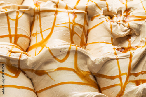 Caramel flavour gelato - full frame detail. Close up of a white surface texture of Caramel Ice cream covered with brown stripes