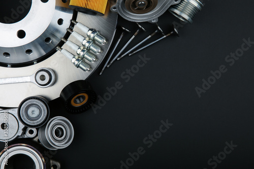 car parts top view on black background with copy space. spark plugs, valves and other parts of a car engine on a black background with empty space