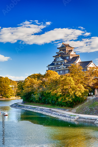 Okayama Crow Castle or Ujo Castle in Okayama City on the Asahi River in Japan. With Little Boat In Foreground.