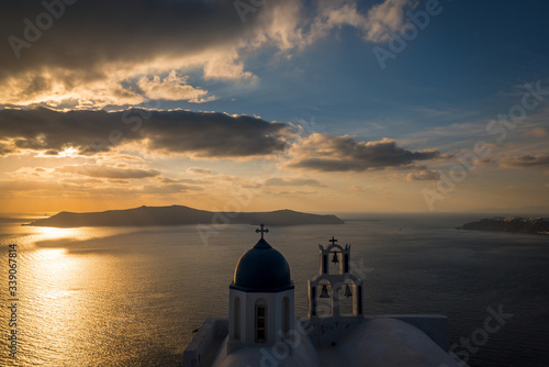 An iconic blue dome church with 3 bells on the island of Santorini