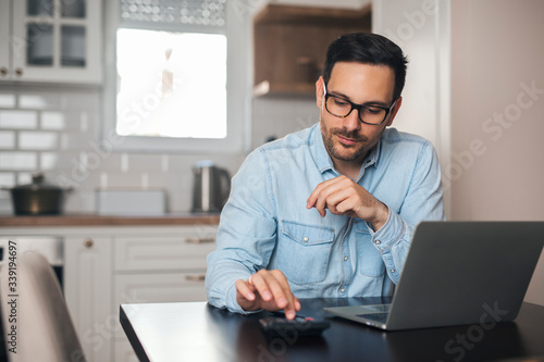 Young accountant count on calculator at home.