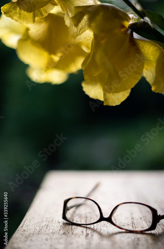 Glasses on the table under a bouquet of yellow gladioli. Selective focus.