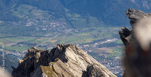 Berge und Felsen auf einem Gipfel in den Schweizer Alpen mit Dorf im Hintergrund