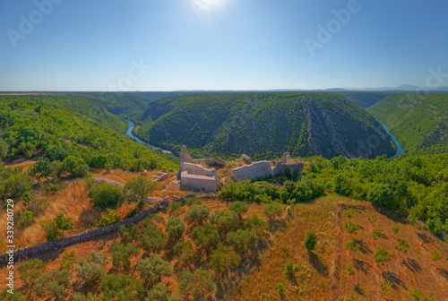 Drone aerial stiched panorama of the archaeological remains of the medieval fort Necven, located on the west side of mountain Promina on top of the canyon of the river Krka in Croatia.