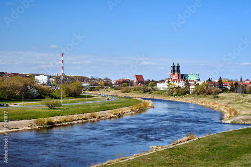 warta river, industrial chimney and cathedral towers in city of Poznan.