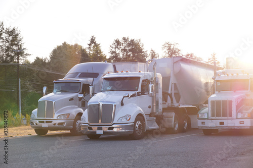 Truck stop. A row of trucks. End of the day, the setting sun.