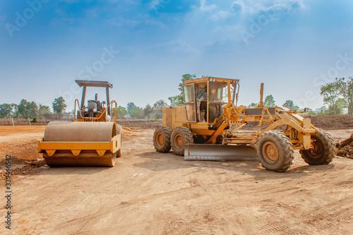 Motor grader and Vibratory roller compactor working in site construction. Road construction heavy equipment