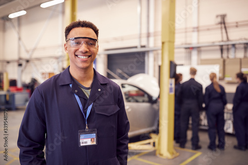 Portrait Of Male Student With Safety Glasses Studying For Auto Mechanic Apprenticeship At College