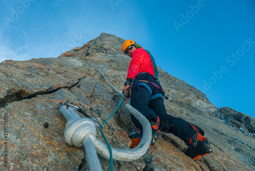 Сlimber guy on a large rock climbs up the crack. Lead rope. Alps, Dent du Geant
