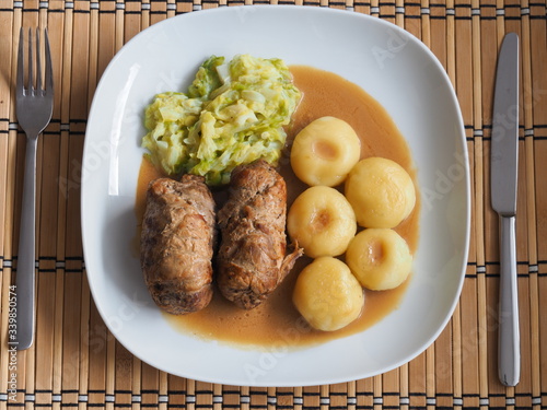 Silesian dumplings with pork roulade and cabbage in roast sauce