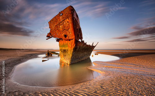 An old shipwreck boat abandoned stand on beach or Shipwrecked off the coast of Ireland