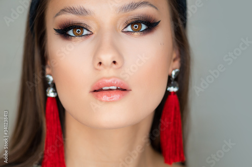 Portrait of a young beautiful brunette woman with bright eye makeup.