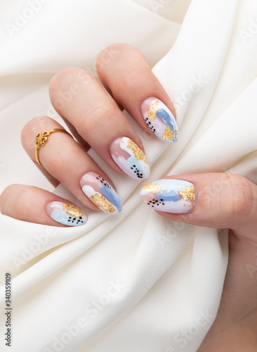 Woman's hand with fashionable nails holding fabric