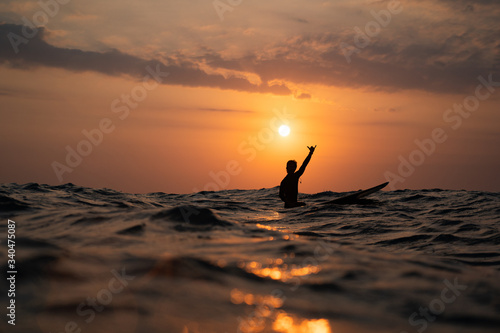 silhouette of a man surfing at sunset in the ocean