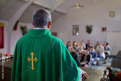 Catholic priest standing on a church podium and preaching, religion