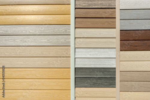 Vinyl siding with imitation wood texture in bright palette of colors. Plastic wall covering for exterior decoration of house. Abstract background for your design with copy space and place for text
