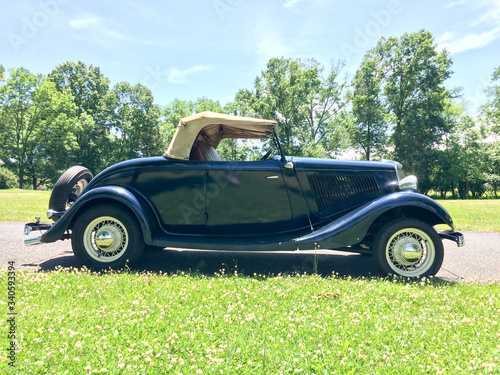 1934 Ford Roadster blue in park on green grass outdoor sky