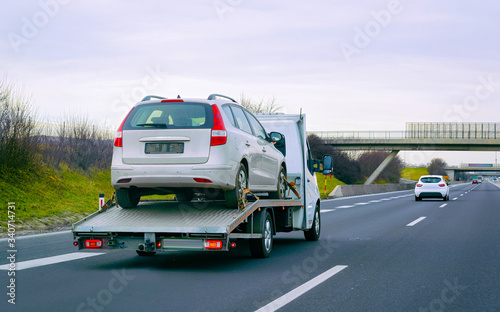 Tow truck with car on warranty on road reflex