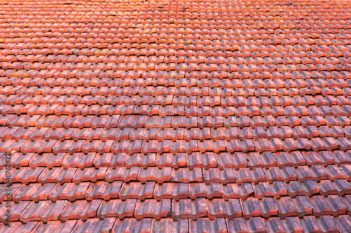 stary dach pokryty czerwoną dachówką