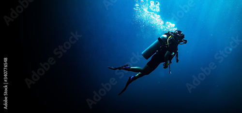 Woman scuba diving in deep blue sea banner on black background 