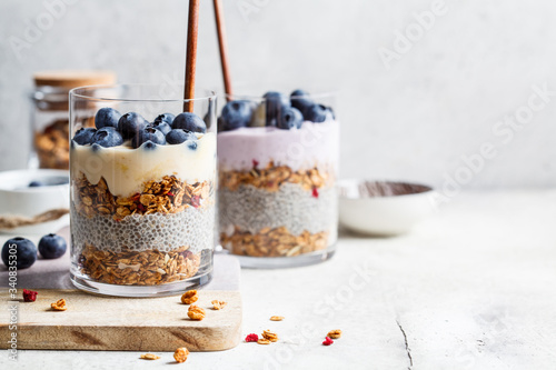 Breakfast parfait with chia, granola, berries and yogurt in a glass. Layer dessert in glass.