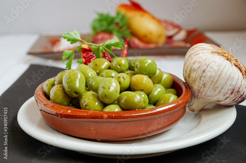 Aceitunas olivas en un bol de barro con un ajo