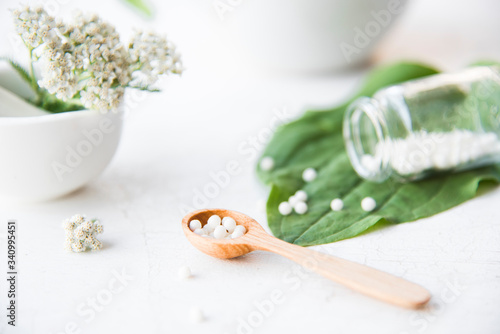 homeopathic granules, medicinal herbs on a natural wooden table on a natural background. alternative medicine and homeopathy