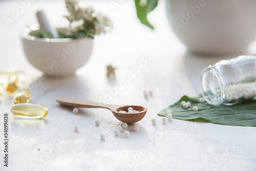 homeopathic granules, medicinal herbs on a natural wooden table on a natural background. alternative medicine and homeopathy