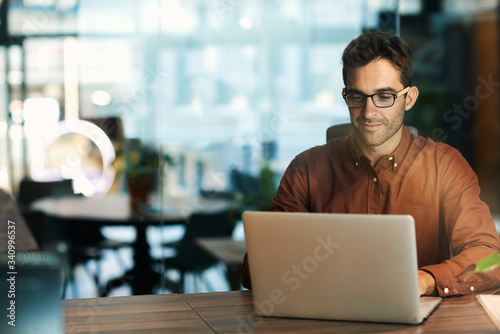 Businessman using a laptop while working late in his office