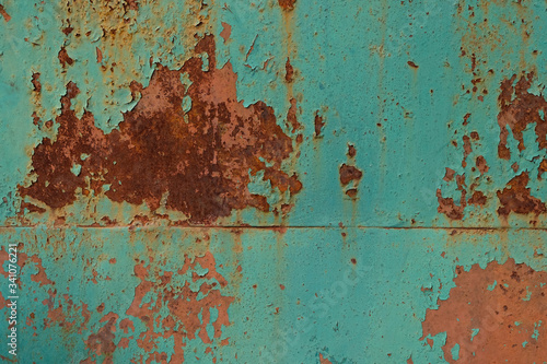 Rust on a painted metal surface. Peeling old paint on gate background. Texture of cracked blue paint and rust on a metal sheet