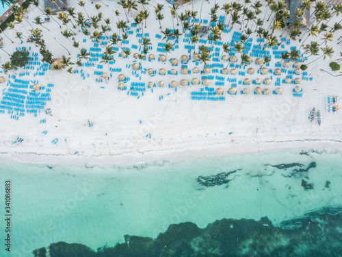 aerial view of tropical beach with lunge chairs and umbrellas