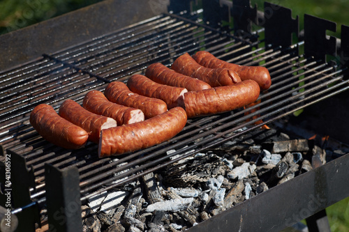 Zarumienione kiełbaski piekące się na grillu 