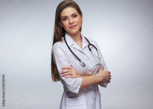 Woman doctor in white uniform standing with crossed arms.