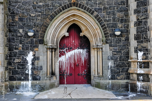 The door of a Roman Catholic Church suffers scorch damage from petrol bombs and paint during a sectarian attack