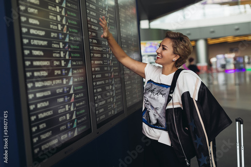 woman at the airport with tickets near the departure board