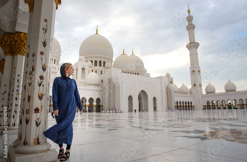a girl in front of a mosque in Abu Dhabi under a palm tree UAE