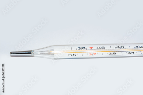 On white surface in center is placed a thermometer to measure the temperature. Glass mercury thermometer.