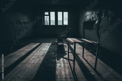 pokój ze zniszczonymi krzesłami w opuszczonym budynku internatu