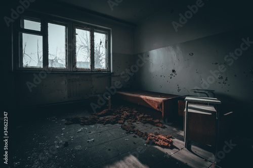 pokój ze zniszczonymi meblami w opuszczonym budynku internatu