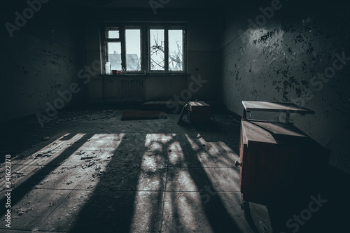 pokój ze zniszczonymi meblami w opuszczonym budynku internatu