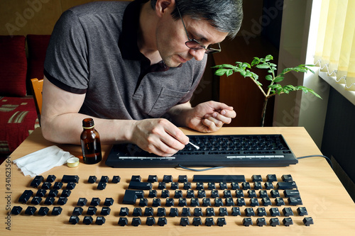 During isolation, a person is busy cleaning the inside of a computer keyboard