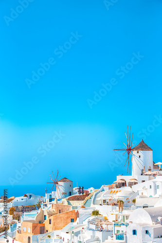 Greek Traditional White Houses and Windmills of Oia or Ia at Santorini Island in Greece at Noon.