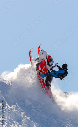 snowmobilers sports riding. Winter extreme ski-doo. an elite snowmobiler is testing a new model of mountain snowmobile, the prototype of 2021. bright snowmobile and suit. rider makes a turn and jump