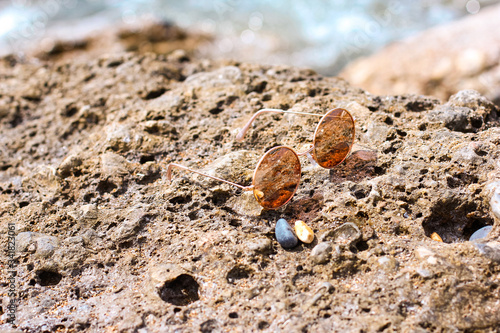 Glasses on the rocky shore near the sea. Round glasses. Tropical vacation and relax travel concept. Glasses on the beach. Mediterranean sea, Turkey. Forgotten thing. 