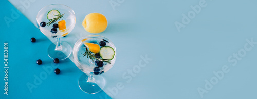 Banner with two glasses of Gin and Tonic isolated on blue background
