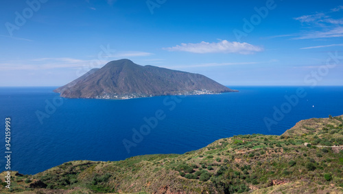 Coast with grass fields of Lipari with view to volcano islands Salina, Alicudi, Filicudi during blue sky day, Sicily Italy.