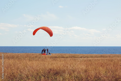 paragliders tandem at the start, sky divers training by the sea shore