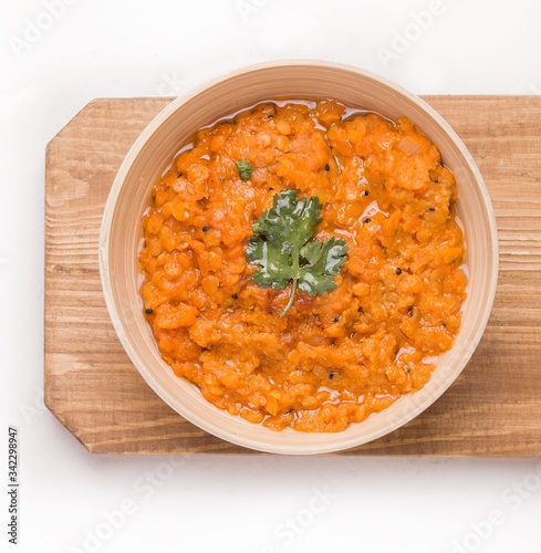 Dhal Indian cream lentil soup in a plate on a wooden board