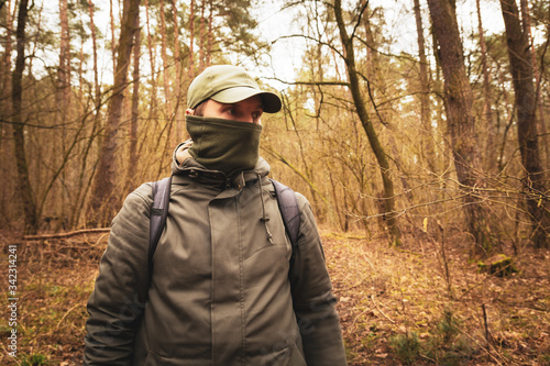 A man with a covered face in the woods